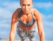 A fit girl doing push-ups on the beach